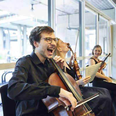 String chamber players laughing while waiting to go on stage